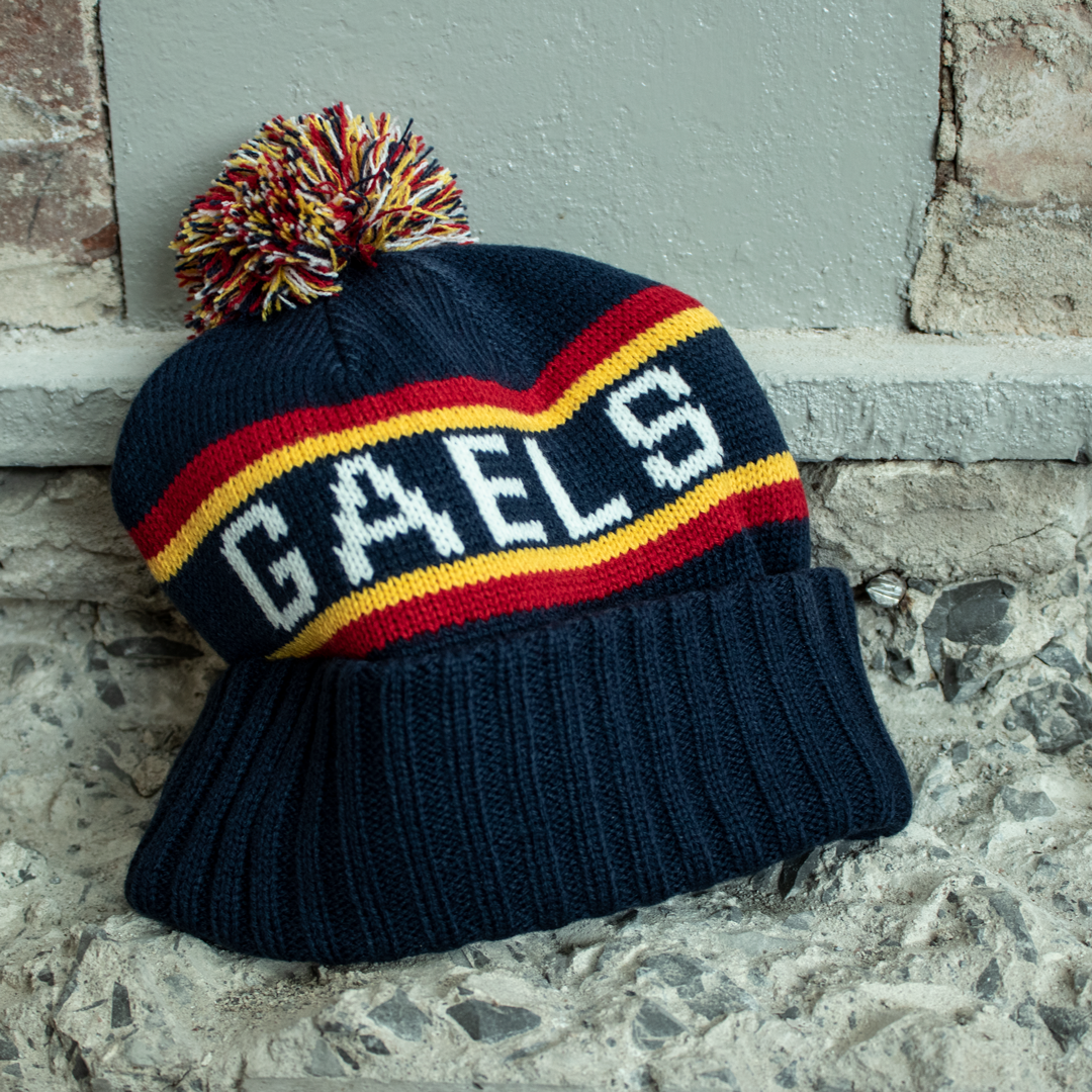 Knitted Tricolour Toque with embroidered Q and knitted Queen's on one side and Knitted Gaels on the opposite side. Tricolour pom adorns the top.